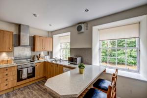 a kitchen with a table and a large window at New Lanark Self Catering Waterhouses in Lanark +39 photos