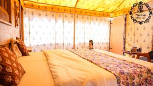 A bed or beds in a room at Rajputana Desert Camp