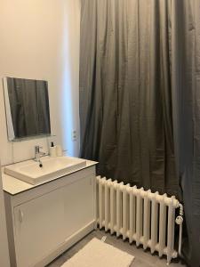 a bathroom with a sink and a shower curtain at Quarto 1 in Brussels