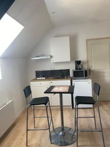 a kitchen with a table and chairs in a room at Cosy Loft New-Yorkais in Guingamp +2 photos