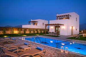 a villa with a swimming pool at night at Oikos- "Your Cretan House" in Angeliana