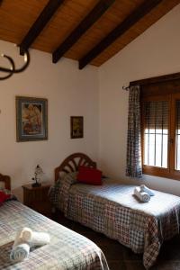 une chambre avec deux lits et une fenêtre dans l'établissement Cortijo de Carmen - Lujo Rustico en el Corazon de la Montaña, à Torrox