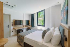 a hotel room with a bed and a television at Taga Hotel in Bitez