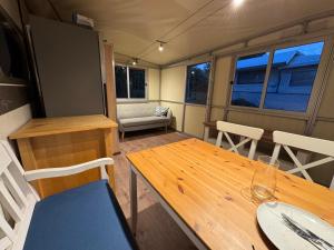 una caravana comedor con mesa de madera y sillas en Campingurlaub Sehlendorf, en Blekendorf 13 fotos más