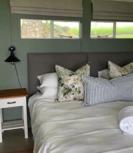 a bedroom with a bed and a table and windows at The Pastures Eston Farm Stay in Mid Illovo