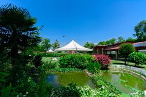 un jardin avec un étang et une tente dans l'établissement Agriturismo Al Buttasella, à Lavariano