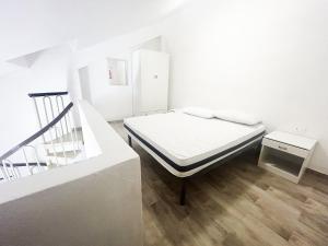 a white room with a bed and a staircase at Case Vacanze a Rossano in Rossano
