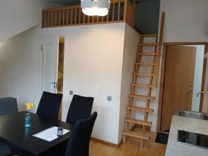 a dining room with a table and a loft bed at Spacy apartment on Laisves avenue in Kaunas