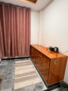a room with a wooden cabinet and a curtain at Sarai Abbottabad in Abbottabad