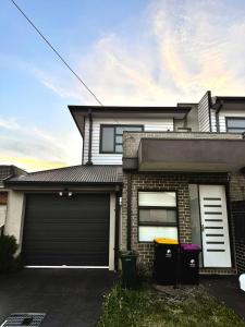 メルボルンにあるTownhouse in Fawknerのガレージと2つの窓があるレンガ造りの家
