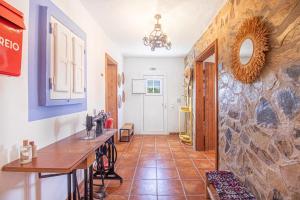 a kitchen with a table and a stone wall at Alma Alentejo Villa in Bicos +63 photos