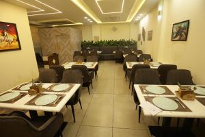a restaurant with tables and chairs in a room at Hotel Neo in Jaipur
