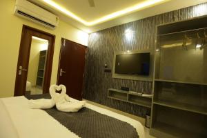 a bedroom with a bed and a tv on a wall at Hotel Neo in Jaipur