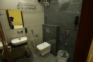 a bathroom with a sink and a toilet and a mirror at Hotel Neo in Jaipur +17 photos