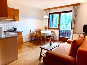 a kitchen and a living room with a table and a couch at Appartements Lärchenhof in Bad Kleinkirchheim