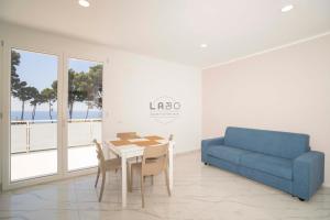 a living room with a table and a blue couch at Residenza Gabbaturco Green Stay Mare e Aeroporto Senza Auto in Santa Domenica