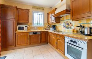 una cocina con armarios de madera y electrodomésticos blancos en Beautiful Home In Lauris With Wifi, en Lauris