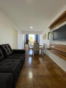 un salon avec un canapé et une salle à manger dans l'établissement Apartamento em Maceió, à Maceió