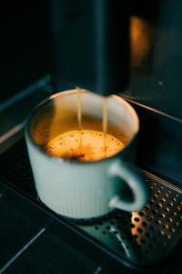 a coffee maker is making a cup of coffee at BIOSFERA Natural Experience Domki Premium w Karkonoszach in Przesieka +18 photos