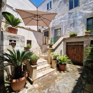 cortile con piante in vaso e ombrellone di Corte SantUlìa a Scorrano