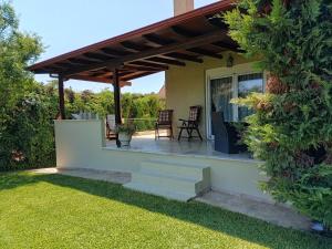 a patio with a wooden pergola at ELENI'S HOUSE FOR VACATION in Nea Plagia