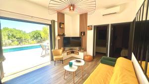 a living room with a television and a large window at havre de paix à Pianottoli proche des plages in Pianottoli-Caldarello