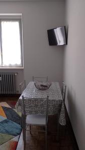 a dining room with a table with chairs and a television at Apartamento Tita in Canosio +6 photos