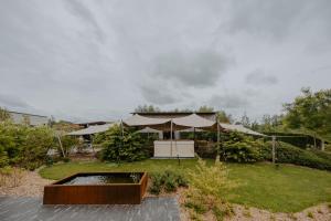 a garden with a tent and a pond at Hangar C gastensuites in Heers