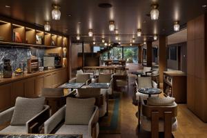 a restaurant with chairs and tables and a bar at One Fukuoka Hotel in Fukuoka