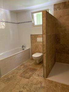 a bathroom with a tub and a toilet and a sink at Combe Rouge in Belvèze +10 photos