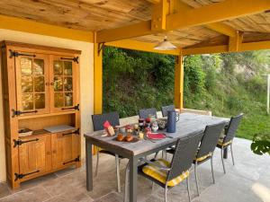 a dining table and chairs on a patio at Combe Rouge in Belvèze