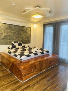 a bedroom with a large bed with a wooden floor at Couple room B in Final Destination Resort in Bolinao