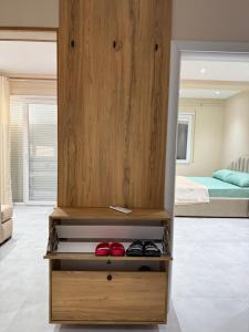 a room with a wooden cabinet with shoes in it at Coastal dreams Golem in Golem +36 photos