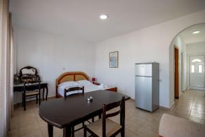 a kitchen and dining room with a table and a refrigerator at Horizon Villa Ksamil in Ksamil