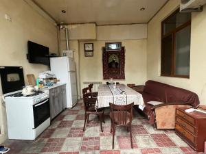 a kitchen and living room with a table and a couch at Huseyn Houses in Ganja