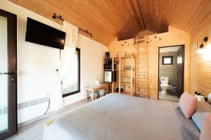 a bedroom with a large bed and a television at Domeniul Horj Casa din Stejar Moisei in Moisei