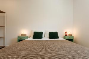 a bedroom with a bed with two green night stands at Red Fox Lodge Serra da Estrela in Eirô