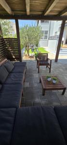 a patio with couches and a table and benches at Apartment Alicia with private pool in Vodice