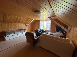 a living room with a couch and a bed in a room at Weisbacken in Lönneberga