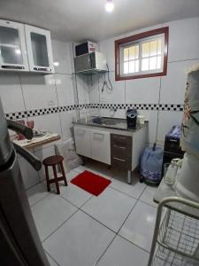 une petite cuisine avec un comptoir et un tapis rouge dans l'établissement Apartamento próximo ao parque do povo, à Campina Grande