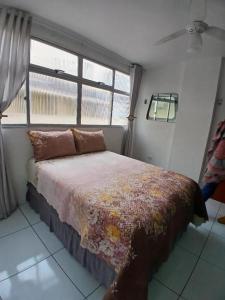 une chambre avec un grand lit avec une fenêtre dans l'établissement Apartamento próximo ao parque do povo, à Campina Grande