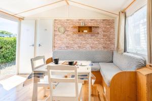 a living room with a couch and a table and chairs at La Baie de la tranquilité in Saint-Pierre-dʼOléron