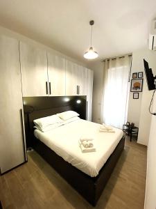 a bedroom with a large bed with white sheets at a pochi passi dalla Metro A e dal Vaticano - NUMA HOUSE in Rome