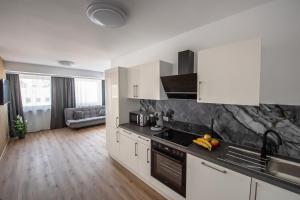 a kitchen with white cabinets and black counter tops at Kaya Residence Hotel in Bad Kreuznach