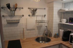 a kitchen with a sink and utensils on the wall at La Suite Presqu'Ile in Lyon