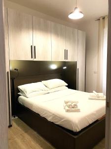 a bedroom with a bed with white sheets and cabinets at a pochi passi dalla Metro A e dal Vaticano - NUMA HOUSE in Rome
