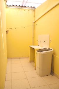 ein gelber Raum mit Toilette und Tisch in der Unterkunft Recanto do Rey in Mucuri + 15 Fotos