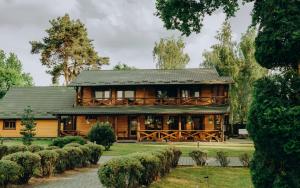 a large wooden house in the middle of a garden at Сосновий Бір, Світязь in Svityazʼ