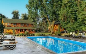 a house with a swimming pool in front of a house at Сосновий Бір, Світязь in Svityazʼ