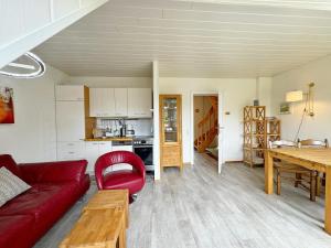 a living room with a red couch and a table at Ferienwohnung in Tinnum auf Syt in Tinnum +21 photos